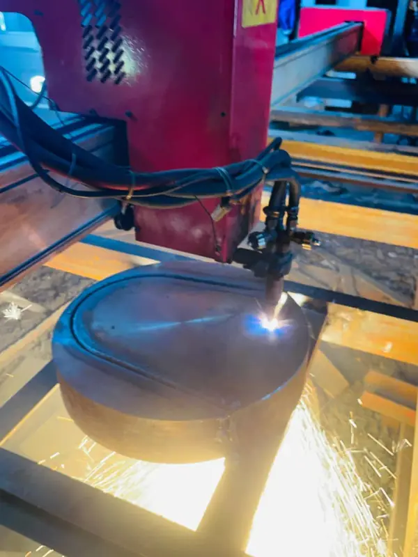 CNC plasma torch cutting a circular profile from steel plate