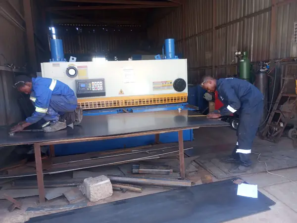Guillotine cutting sheet metal in the workshop